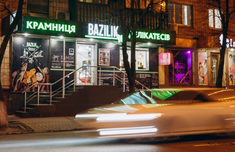 cars parked in front of store during night time